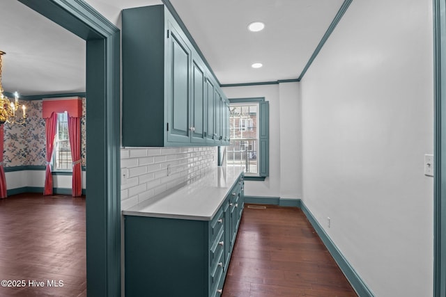 kitchen with plenty of natural light, ornamental molding, light countertops, and dark wood-type flooring