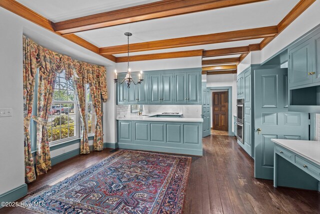 kitchen with light countertops, backsplash, dark wood-style floors, beamed ceiling, and an inviting chandelier