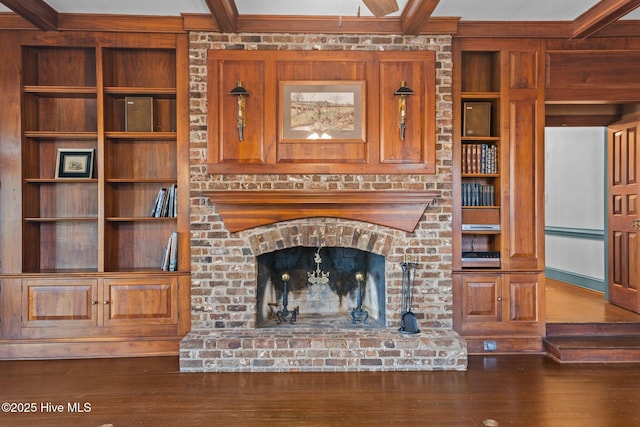 unfurnished living room featuring built in features, a fireplace, beamed ceiling, and wood finished floors