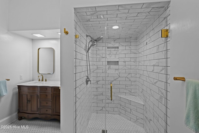 full bath featuring tile patterned flooring, a shower stall, vanity, and baseboards