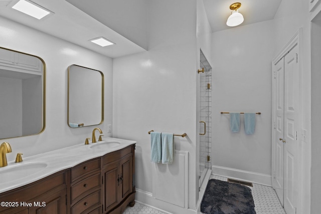 full bath featuring double vanity, a sink, visible vents, and a shower stall