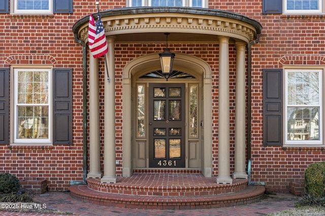 view of exterior entry featuring brick siding