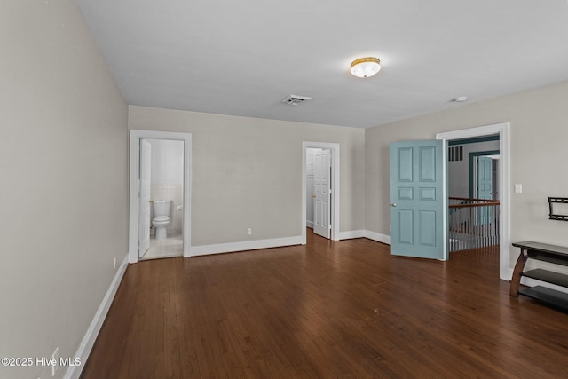 unfurnished room with wood finished floors, visible vents, and baseboards