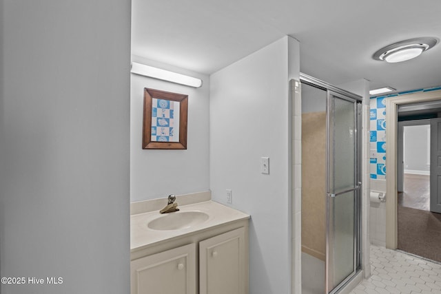 bathroom with a shower stall, tile patterned flooring, and vanity