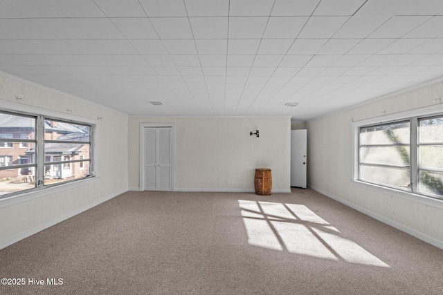 carpeted spare room featuring baseboards