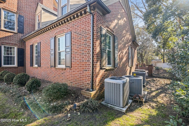 view of side of property featuring brick siding and cooling unit