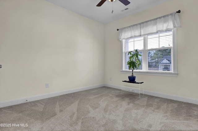 carpeted empty room with visible vents, baseboards, and a ceiling fan