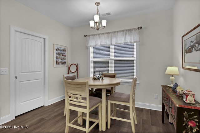 dining area with baseboards, visible vents, a chandelier, and wood finished floors