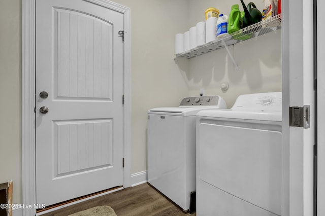 laundry room featuring dark wood-type flooring, laundry area, washer and clothes dryer, and baseboards