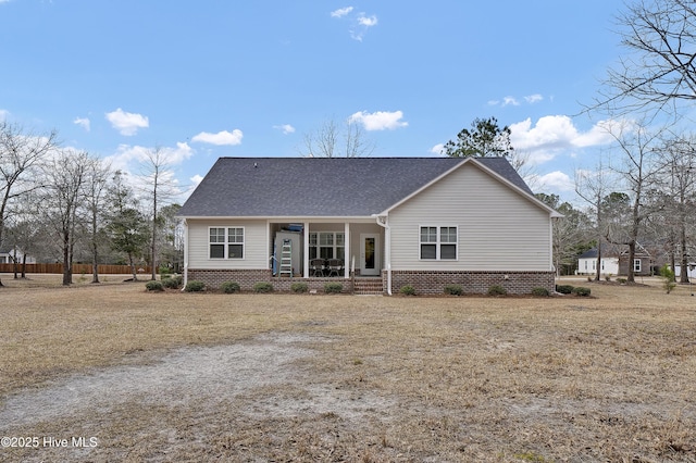 view of front of home featuring covered porch, a shingled roof, and brick siding