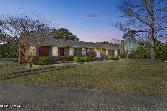 single story home with brick siding and a front lawn