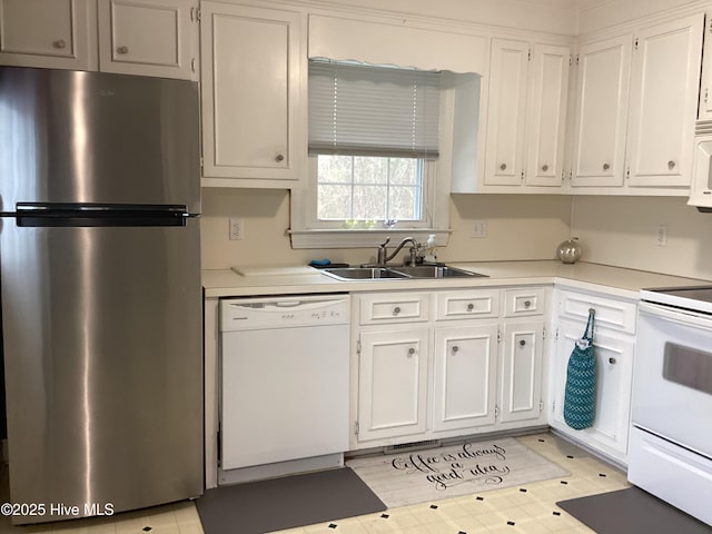 kitchen with a sink, white appliances, white cabinetry, and light countertops