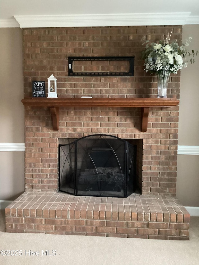 interior details with a brick fireplace and crown molding