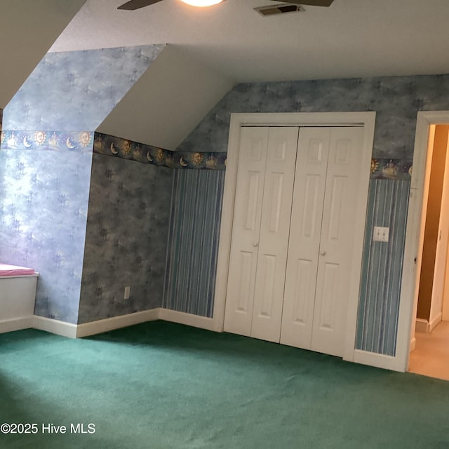 additional living space featuring vaulted ceiling, visible vents, wallpapered walls, and carpet floors