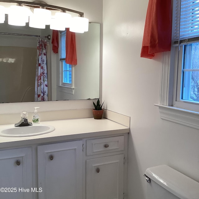 full bathroom with toilet, vanity, and a shower with curtain