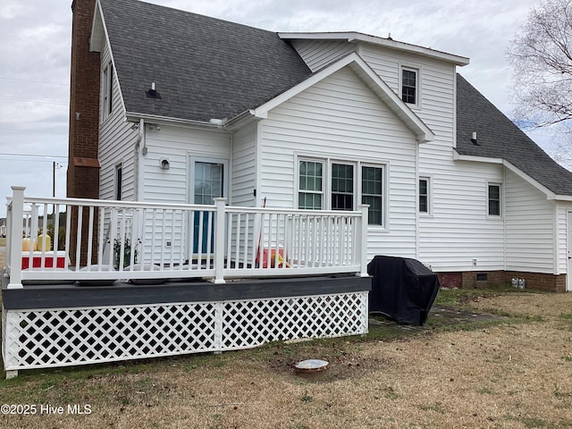 rear view of house with crawl space, a deck, a chimney, and roof with shingles