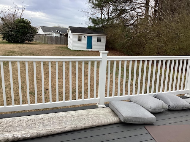 deck featuring an outdoor structure, a yard, and fence