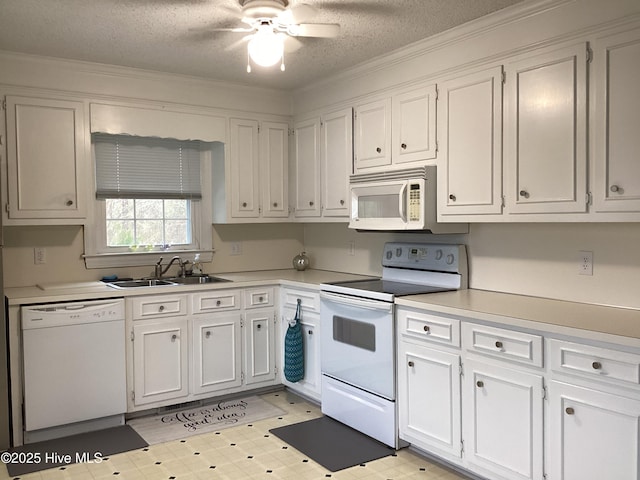 kitchen featuring light floors, white appliances, white cabinets, and a sink