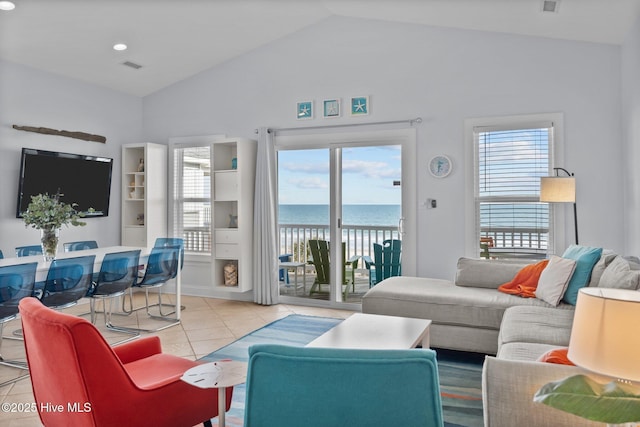 living room with a water view, light tile patterned floors, visible vents, and lofted ceiling