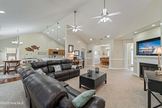 living room with a fireplace with flush hearth, high vaulted ceiling, ceiling fan with notable chandelier, decorative columns, and baseboards