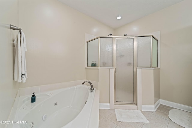 bathroom featuring tile patterned flooring, a jetted tub, baseboards, and a stall shower