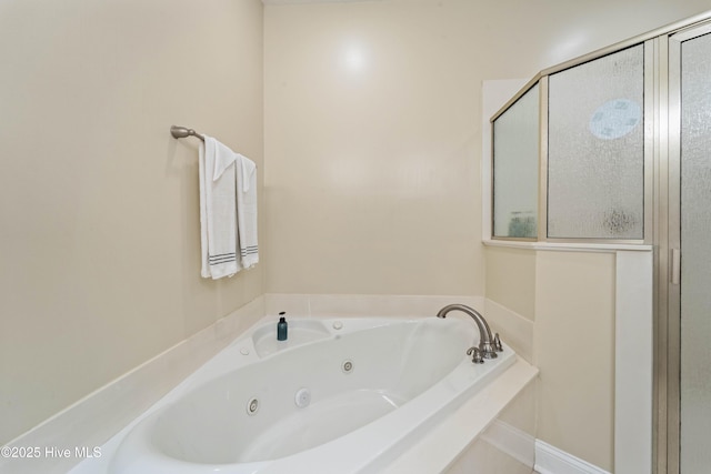 bathroom with a jetted tub and a stall shower