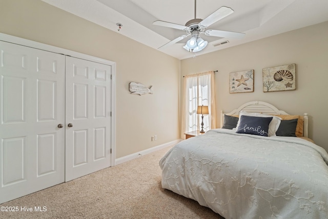 bedroom with a ceiling fan, carpet, visible vents, baseboards, and a closet