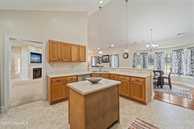 kitchen with visible vents, a sink, a peninsula, light countertops, and dishwasher