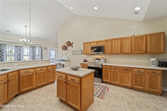 kitchen with high vaulted ceiling, stainless steel appliances, light countertops, a notable chandelier, and brown cabinets