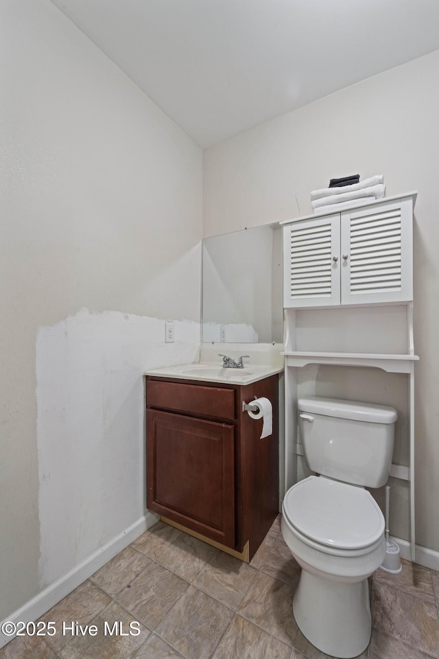 bathroom with vanity, toilet, and baseboards