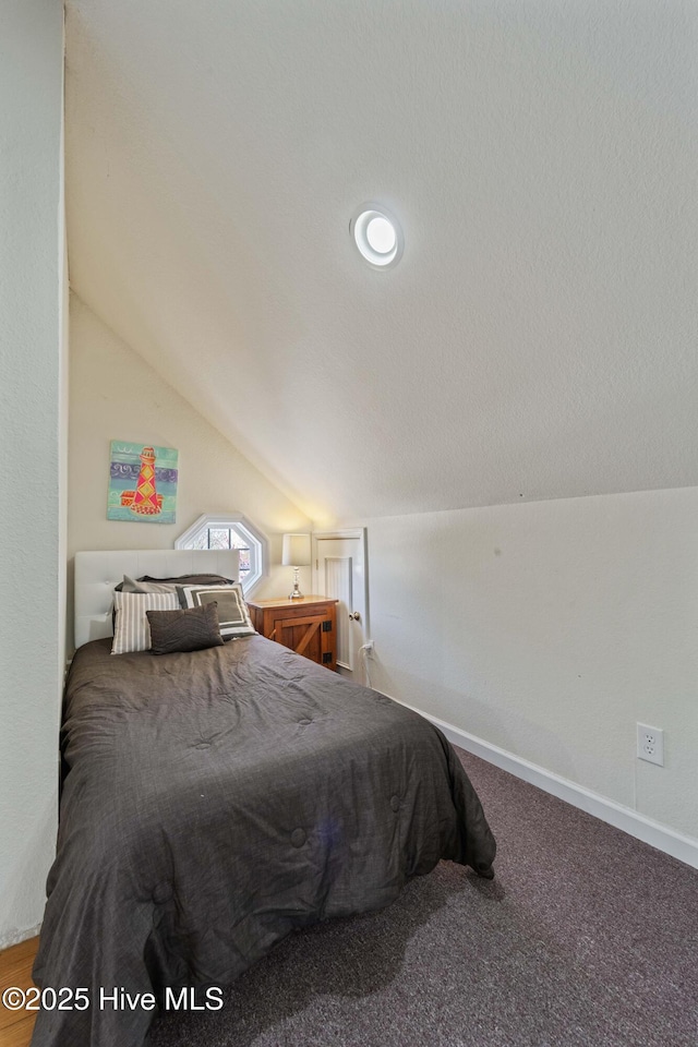 carpeted bedroom with baseboards and lofted ceiling