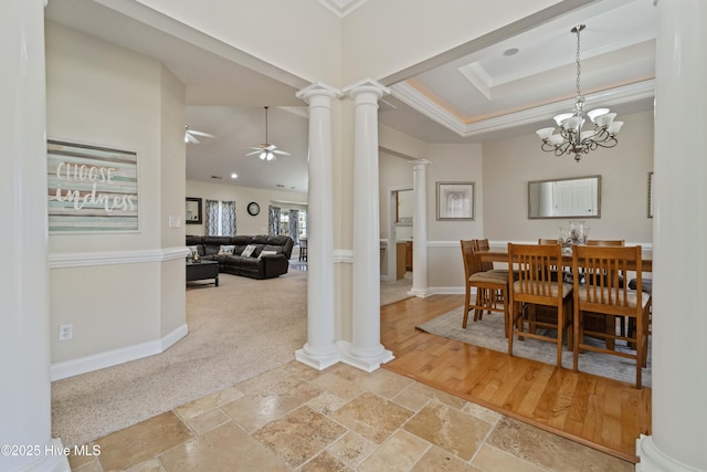 dining room featuring baseboards, a tray ceiling, ornamental molding, decorative columns, and ceiling fan with notable chandelier