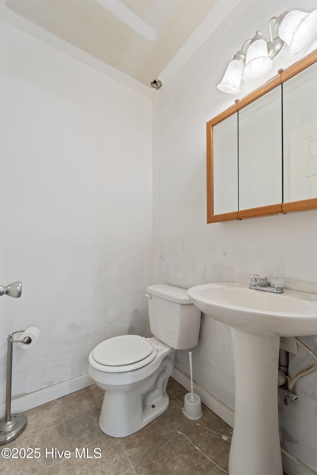 bathroom featuring tile patterned floors, toilet, and baseboards