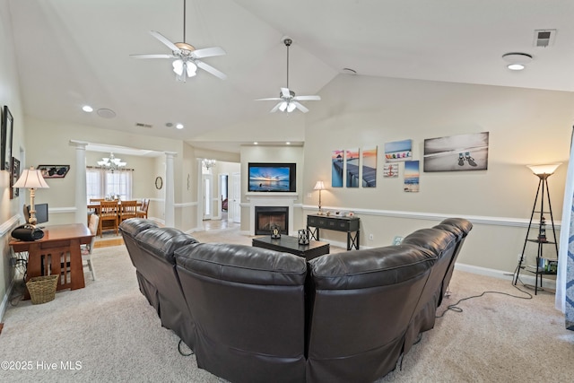 living room featuring visible vents, a ceiling fan, carpet floors, a fireplace, and decorative columns