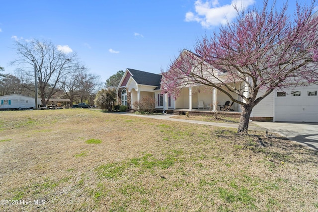 view of front of house with a porch, concrete driveway, and a front yard