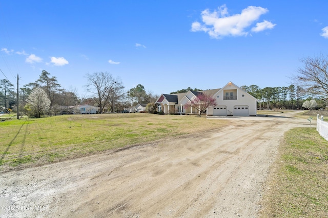 view of front of house featuring a front yard, an attached garage, and driveway