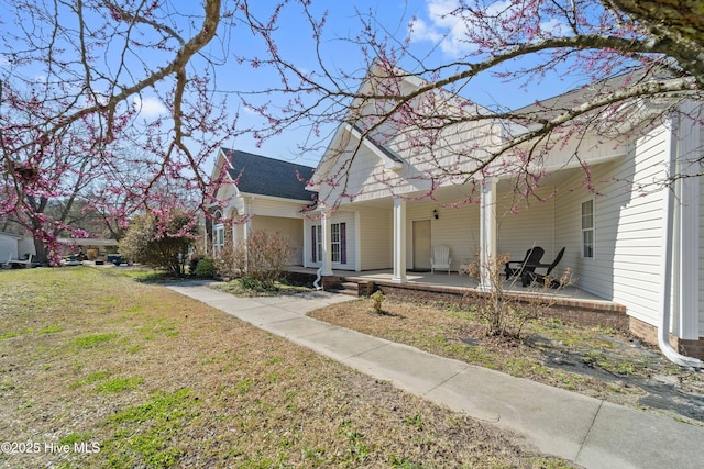 view of home's exterior with a lawn and covered porch