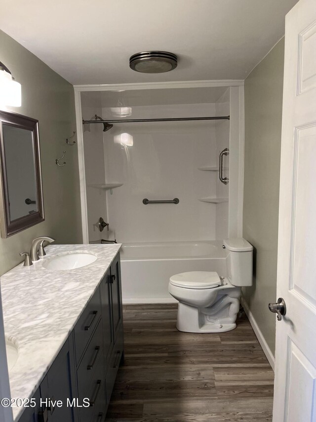 full bathroom with toilet, a sink, wood finished floors, shower / bathing tub combination, and double vanity