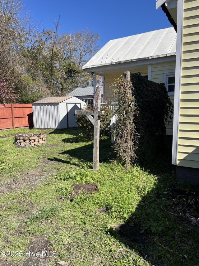 view of yard with an outbuilding, a storage shed, and fence