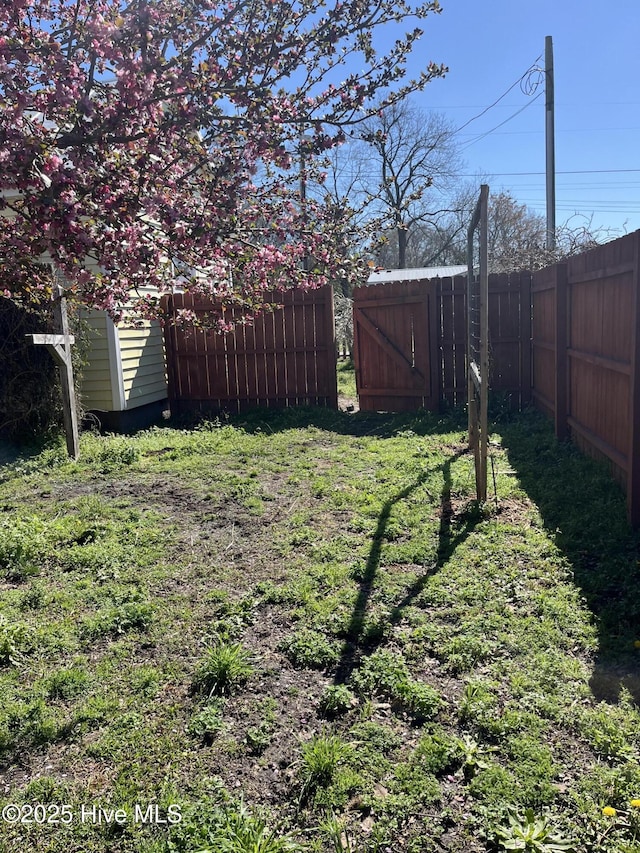 view of yard with an outbuilding, a storage shed, and a fenced backyard