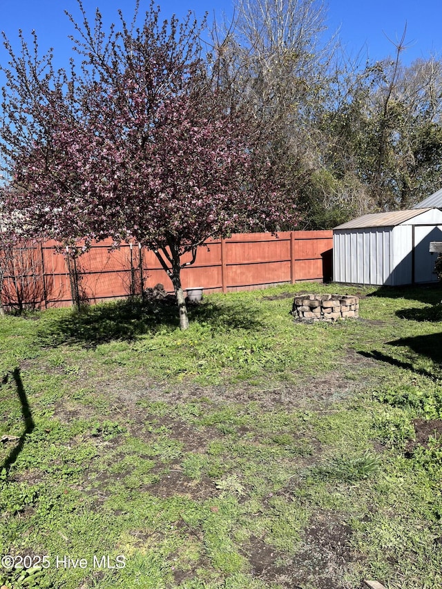view of yard featuring an outdoor structure, fence, and a shed
