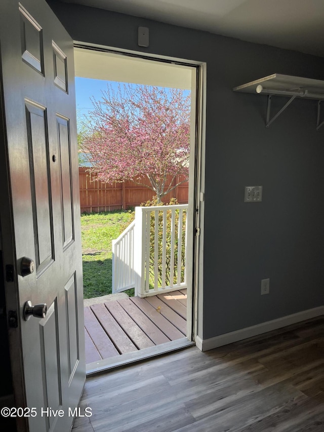 doorway featuring wood finished floors and baseboards