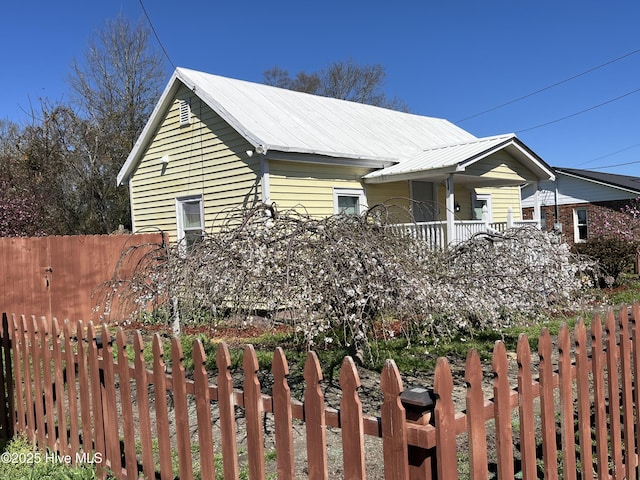 view of property exterior featuring a fenced front yard and metal roof