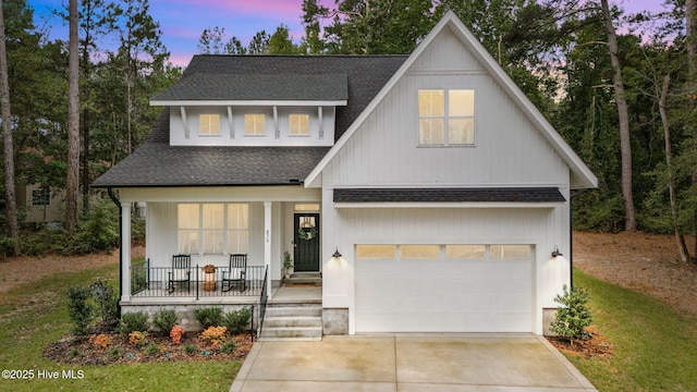 view of front of home featuring covered porch, a shingled roof, and concrete driveway