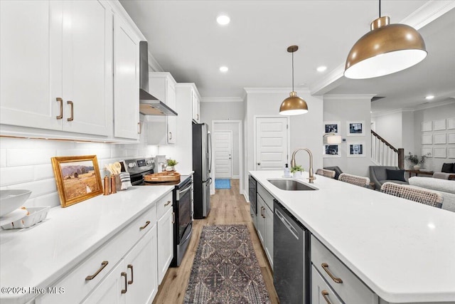 kitchen featuring white cabinets, a kitchen island with sink, stainless steel appliances, crown molding, and a sink