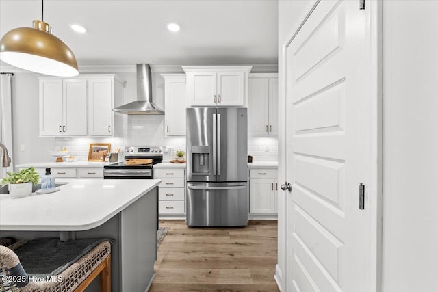 kitchen featuring stainless steel appliances, tasteful backsplash, light countertops, white cabinets, and wall chimney exhaust hood