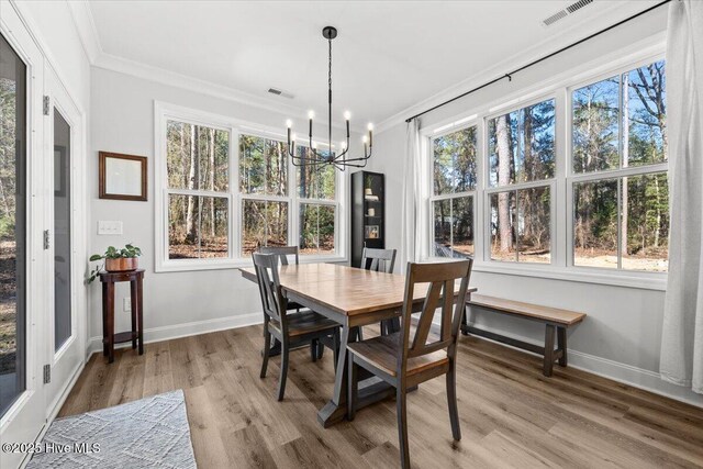 876 Elderberry Dr, Vass, NC 28394 - dining room featuring visible vents, a chandelier, crown molding, and light wood finished floors