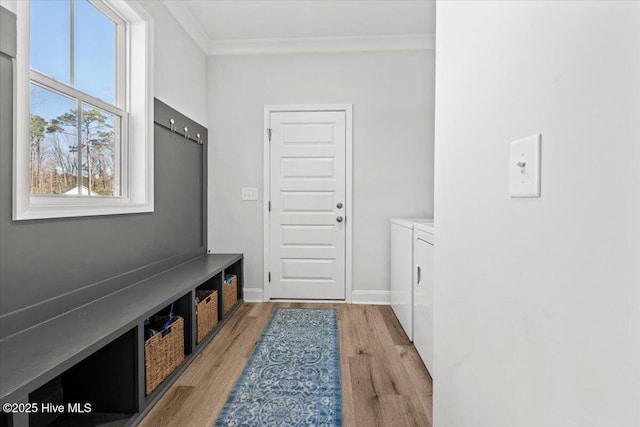 mudroom featuring light wood-type flooring, baseboards, crown molding, and independent washer and dryer