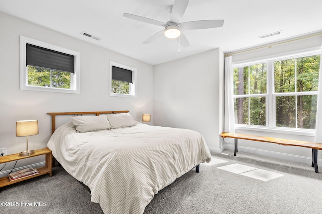 carpeted bedroom with baseboards, visible vents, and a ceiling fan