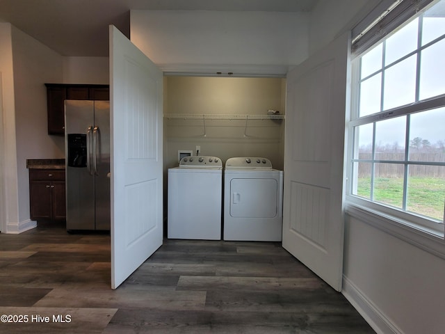 clothes washing area with baseboards, dark wood-style floors, laundry area, and washer and clothes dryer